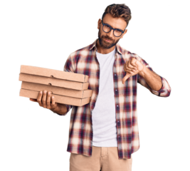Young hispanic man holding delivery pizza box with angry face, negative sign showing dislike with thumbs down, rejection concept