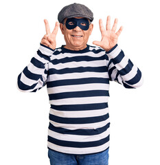 Senior handsome man wearing burglar mask and t-shirt showing and pointing up with fingers number seven while smiling confident and happy.