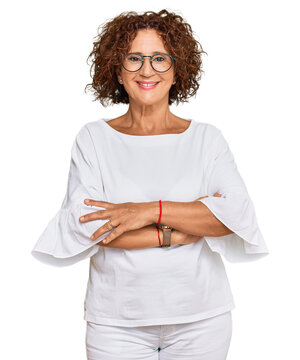 Beautiful middle age mature woman wearing casual clothes and glasses happy face smiling with crossed arms looking at the camera. positive person.