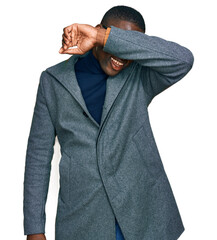 Young african american man wearing business clothes and glasses covering eyes with arm smiling cheerful and funny. blind concept.