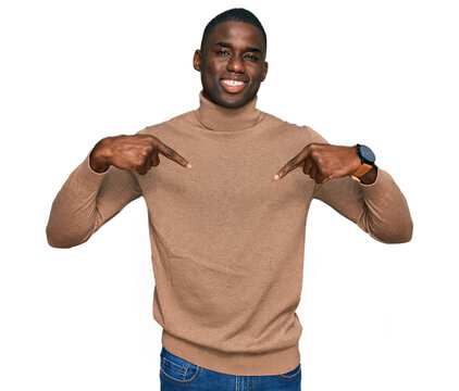 Young african american man wearing casual winter sweater looking confident with smile on face, pointing oneself with fingers proud and happy.