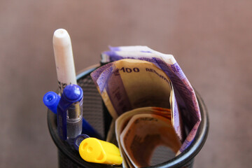 100 rupees note kept in basket with pens. Indian Currency