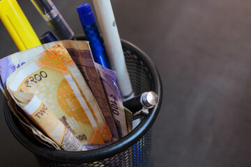 200 rupees note kept in basket with pens. Indian Currency