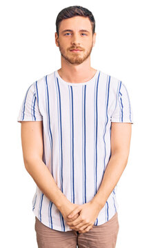 Handsome young man with bear wearing casual clothes with serious expression on face. simple and natural looking at the camera.