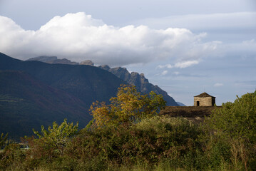 Fototapeta na wymiar View of Romanesque church with background mountain and clouds
