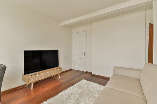 Interior Of Living Room With White Wall Above Comfortable Couch And TV