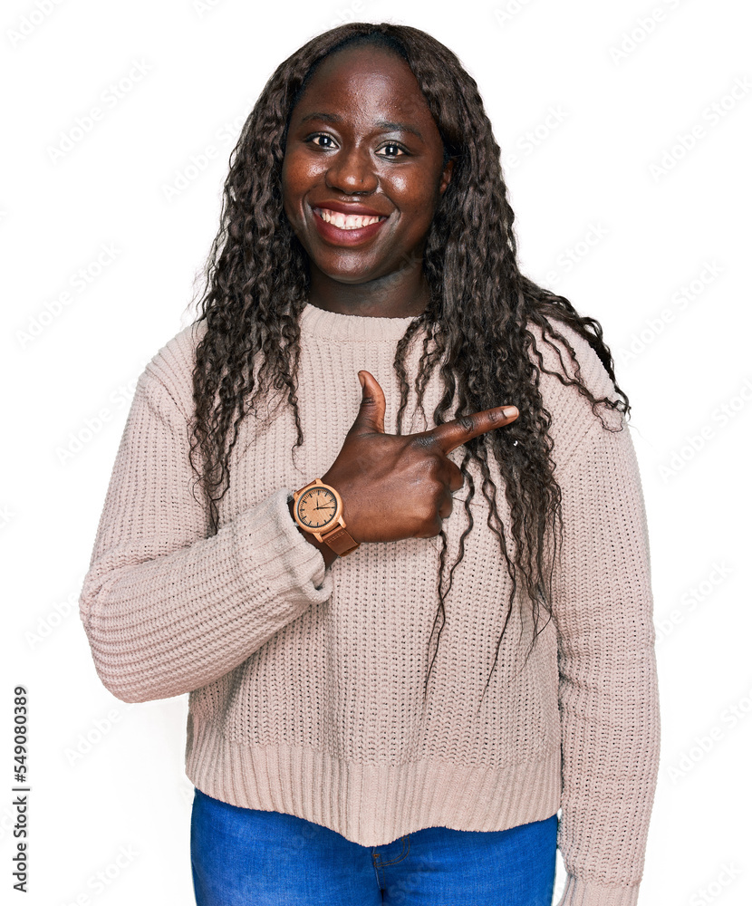 Poster Young african woman wearing wool winter sweater cheerful with a smile on face pointing with hand and finger up to the side with happy and natural expression