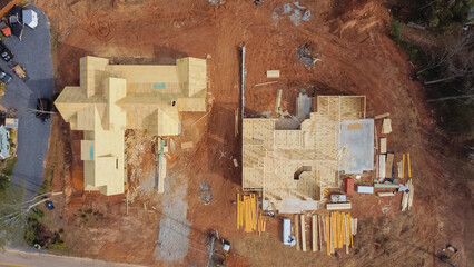 Aerial view construction site with wooden house framing of beams and rafters, joints, trusses in...