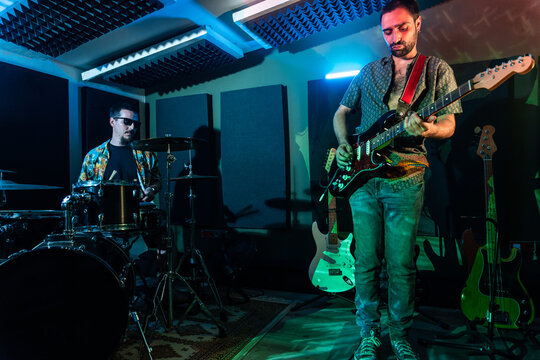 Men playing guitar and drums in club