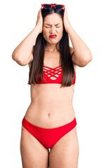 Naklejka premium Young beautiful caucasian woman wearing bikini suffering from headache desperate and stressed because pain and migraine. hands on head.