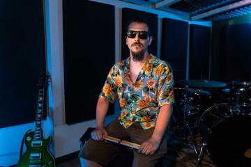 Male musician sitting on amplifier in studio