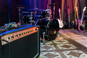 Modern amplifier near drums in studio