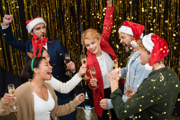 High angle view of multiethnic business people with champagne dancing near confetti and tinsel...