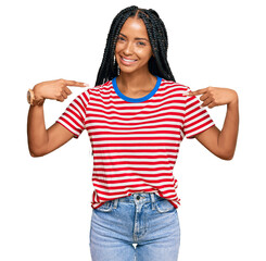 Beautiful hispanic woman wearing casual clothes looking confident with smile on face, pointing...