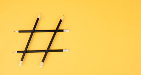 Hashtag made from pencils, social media communication, influencer and followers, viral content trend, yellow color
