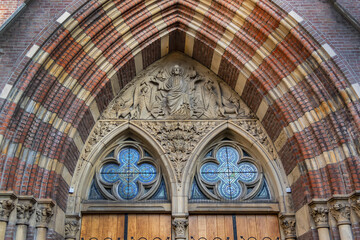 Neo-Gothic Post Horn Church (Posthoornkerk, 1863) with three slender towers on bustling Haarlemmerstraat - one of most important surviving XIX century churches. Sunset. Amsterdam, the Netherlands.