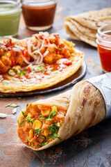 Aloo Corn or potato Corn paratha roll kathi shawarma wrap with dipping sauce isolated on background side view of indian fastfood