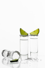 tequila shots with lime and salt on white background