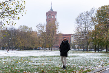 Young bearded male tourist with the Rotes Rathaus in the background and all snowed in.
