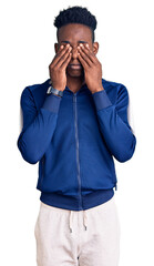 Young african american man wearing sportswear rubbing eyes for fatigue and headache, sleepy and...