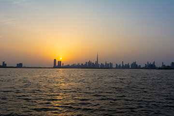 Obraz premium Sunset over Dubai skyscrapers with calm water and beautiful colors