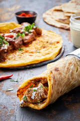 Chicken Bhuna paratha roll kathi shawarma wrap with dipping sauce isolated on background side view...