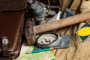 Geological fieldwork tools - field vintage geology concept. The inscription on the sleeve chevron...