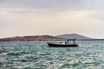 The boat is parked in the sea against the backdrop of the islands. Shallow depth of field.