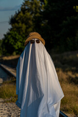 Naklejka premium White ghost with black eyes, made from a bedsheet. whit hat