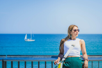 Joven mujer latina en el mar y de fondo un yate