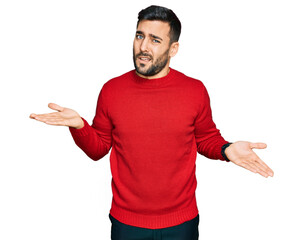 Young hispanic man wearing casual clothes clueless and confused with open arms, no idea concept.