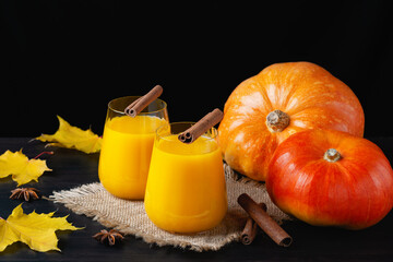 Healthy pumpkin juice in glasses on autumn background
