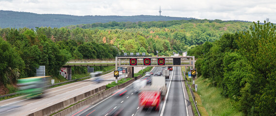 traffic on the autobahn with a speed limit of 80 kmh between the green forest 