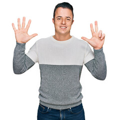 Naklejka premium Handsome young man wearing casual winter sweater showing and pointing up with fingers number eight while smiling confident and happy.