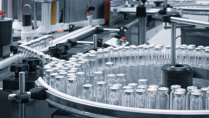 Pharmaceutical industry. Production line machine conveyor with glass bottles ampoules at factory. Pharmaceutical industry concept background. - obrazy, fototapety, plakaty