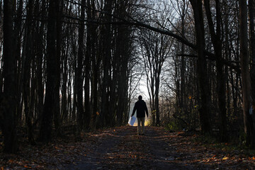 Man walking in the dark autumn forest and holding drawing with colourful square in the left hand. Photo was taken 25 October 2022 year, MSK time in Russia. - 549093977
