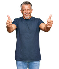 Middle age grey-haired man wearing casual clothes approving doing positive gesture with hand, thumbs up smiling and happy for success. winner gesture.