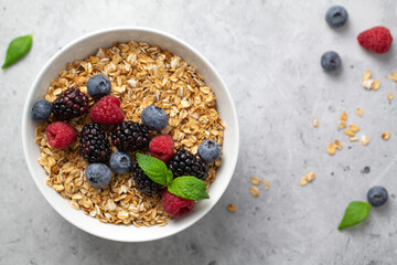 Granola with fresh raspberries, blueberries and blackberries for breakfast in a bowl. Concept  healthy breakfast.