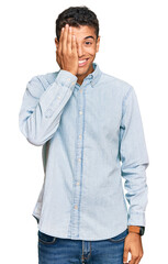 Fototapeta premium Young handsome african american man wearing casual clothes covering one eye with hand, confident smile on face and surprise emotion.