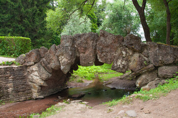Vintage old unusual beautiful bridge made of large stones in the city park