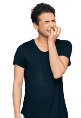 Fototapeta na wymiar Young handsome man wearing casual black t shirt looking stressed and nervous with hands on mouth biting nails. anxiety problem.
