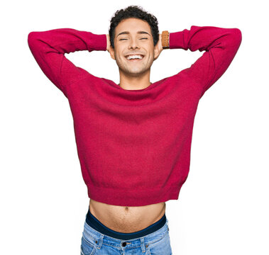 Young handsome man wearing casual clothes relaxing and stretching, arms and hands behind head and neck smiling happy