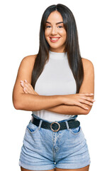 Young beautiful hispanic girl wearing casual clothes happy face smiling with crossed arms looking at the camera. positive person.