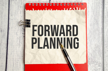red notebook, forward planning words and white background