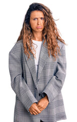 Young hispanic woman with tattoo wearing business oversize jacket depressed and worry for distress, crying angry and afraid. sad expression.