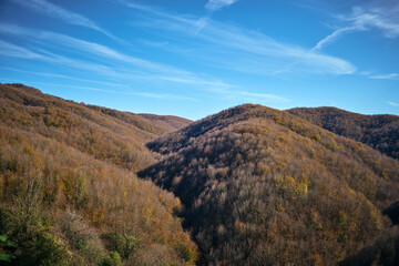 Fototapeta premium Landscape of tuscan mountains in autumn with blue sky and contrails