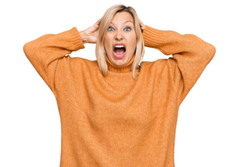 Middle age caucasian woman wearing casual winter sweater crazy and scared with hands on head, afraid and surprised of shock with open mouth