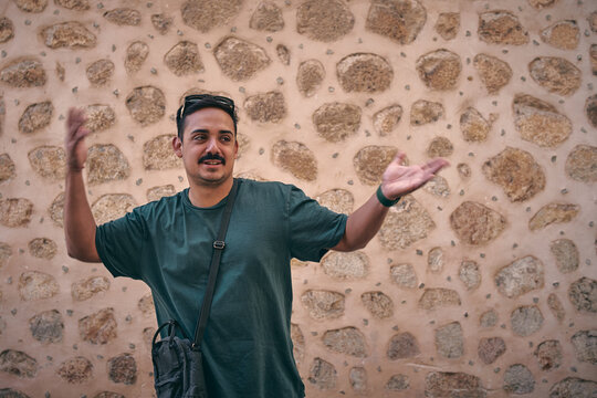 Hombre joven se muestra contento y alegre en un pueblo mediterráneo