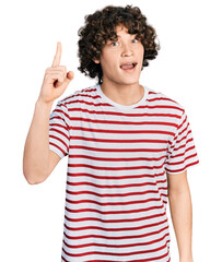 Caucasian teenager wearing casual clothes pointing finger up with successful idea. exited and happy. number one.