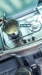 Kochen im camper beim camping. Gaskocher mit Flamme. Topf mit Nudeln zubereiten.